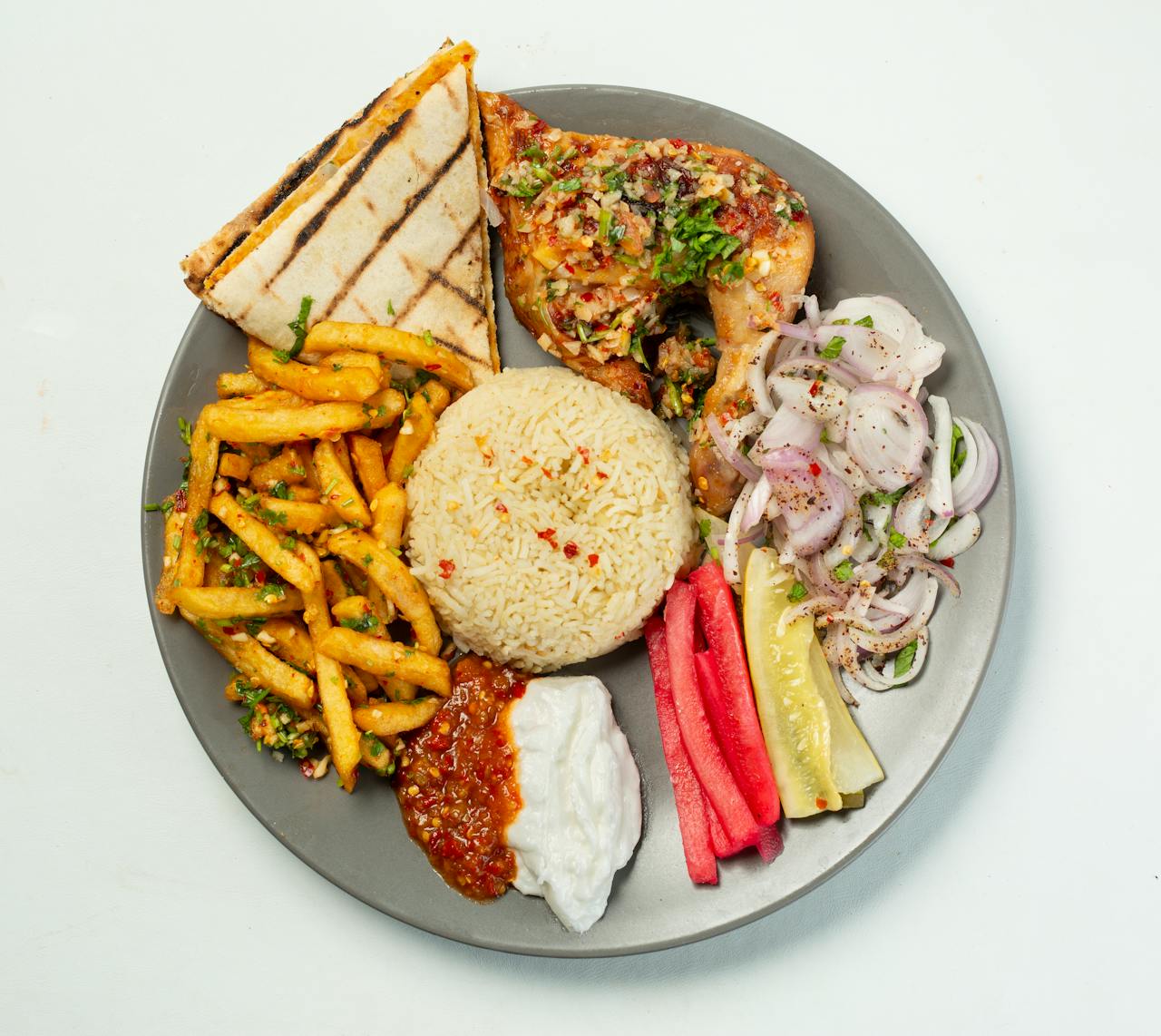 our-services-2 A flavorful Bangladeshi chicken meal with fries, rice, naan, and fresh sides on a plate.